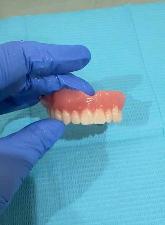 A finished denture held ready for fitting